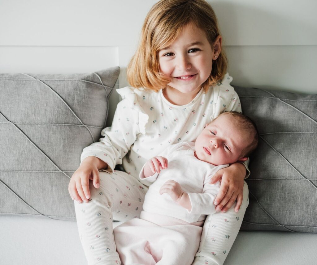 older sister holding baby sibling