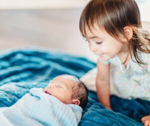 older sibling looking at baby